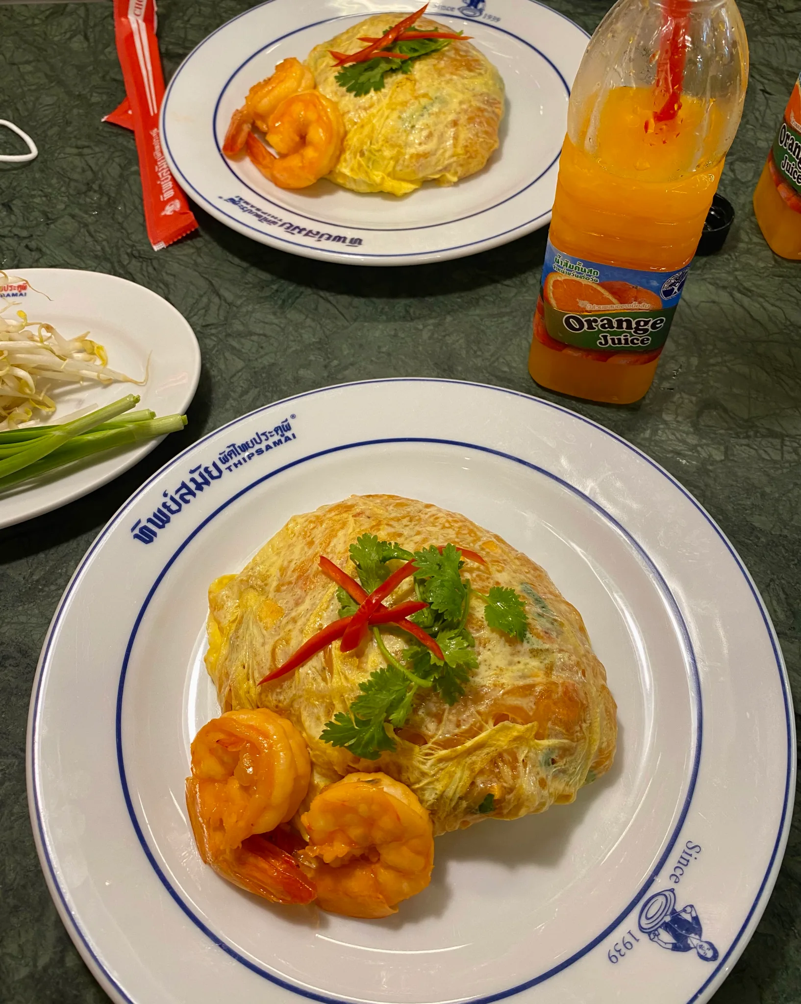 Thipsamai pad thai wrapped in egg with orange juice